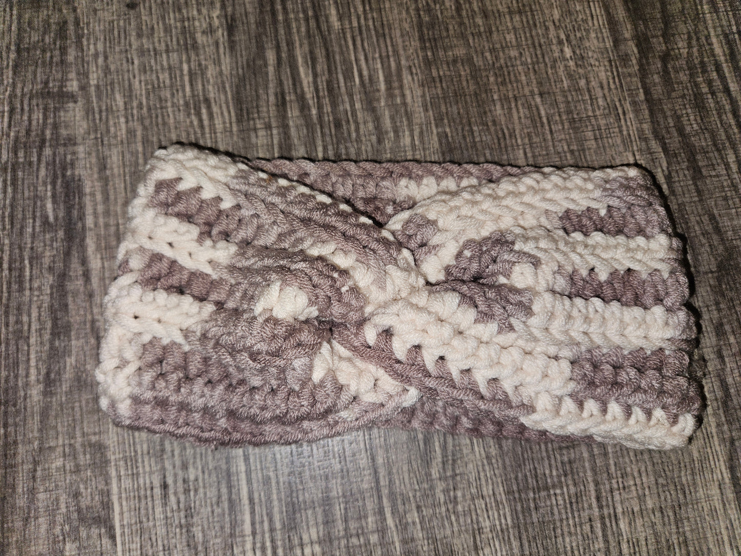 Crocheted headband with a bow on a wooden surface