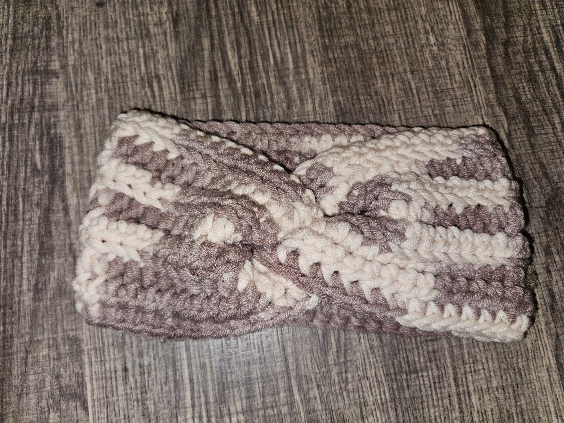 Crocheted headband with a bow on a wooden surface